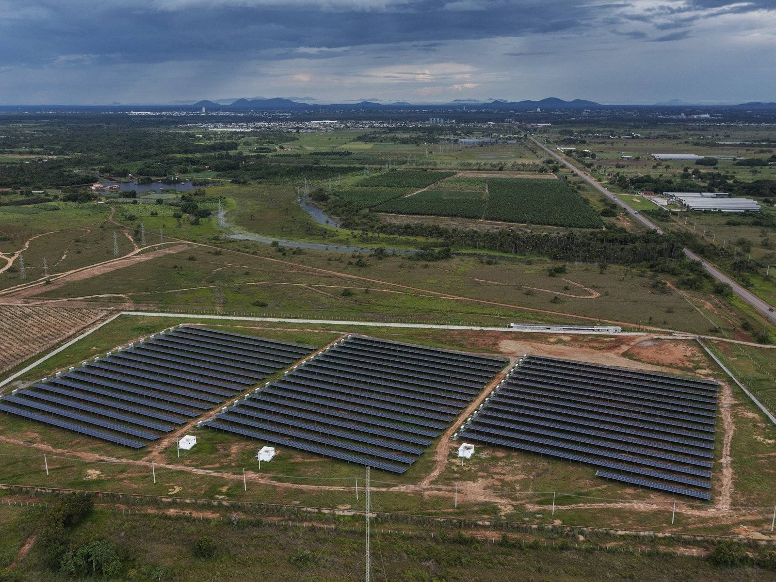 Usina solar de solo de grande porte, com longas fileiras de pain&eacute;is em terreno aberto