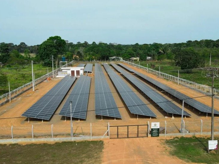 Usina solar de solo com fileiras de pain&eacute;is e estrada de terra ao lado